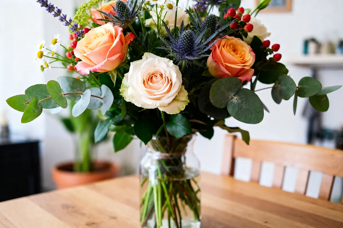 Bouquet de fleurs colorées sur table en bois célébrant Un Jour une Fleur